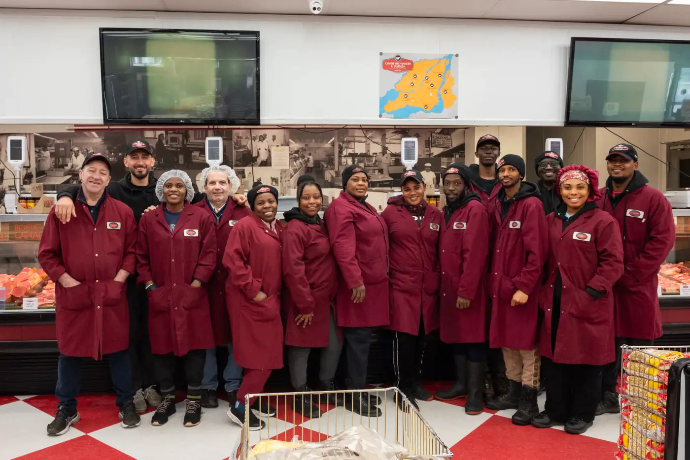An Iasenza store team in burgundy coats gathered in front of the meat counter