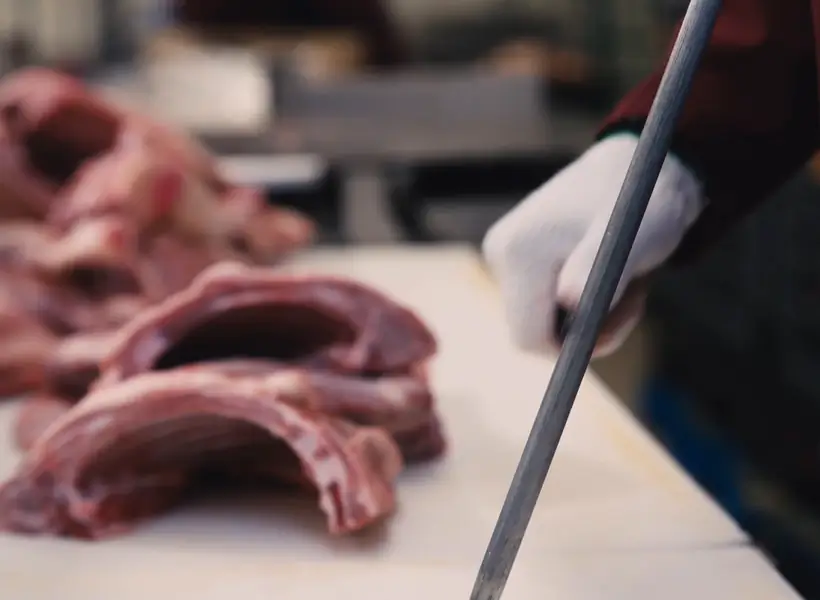 An Iasenza butcher preparing lamb ribs