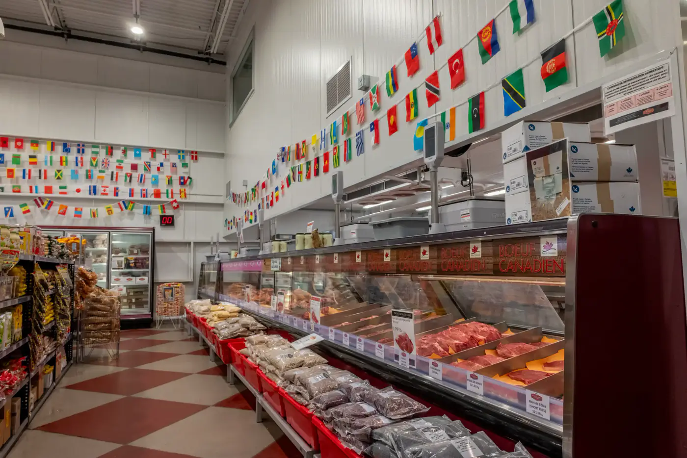 Meat counter under a row of world flags at the Dollard-des-Ormeaux store