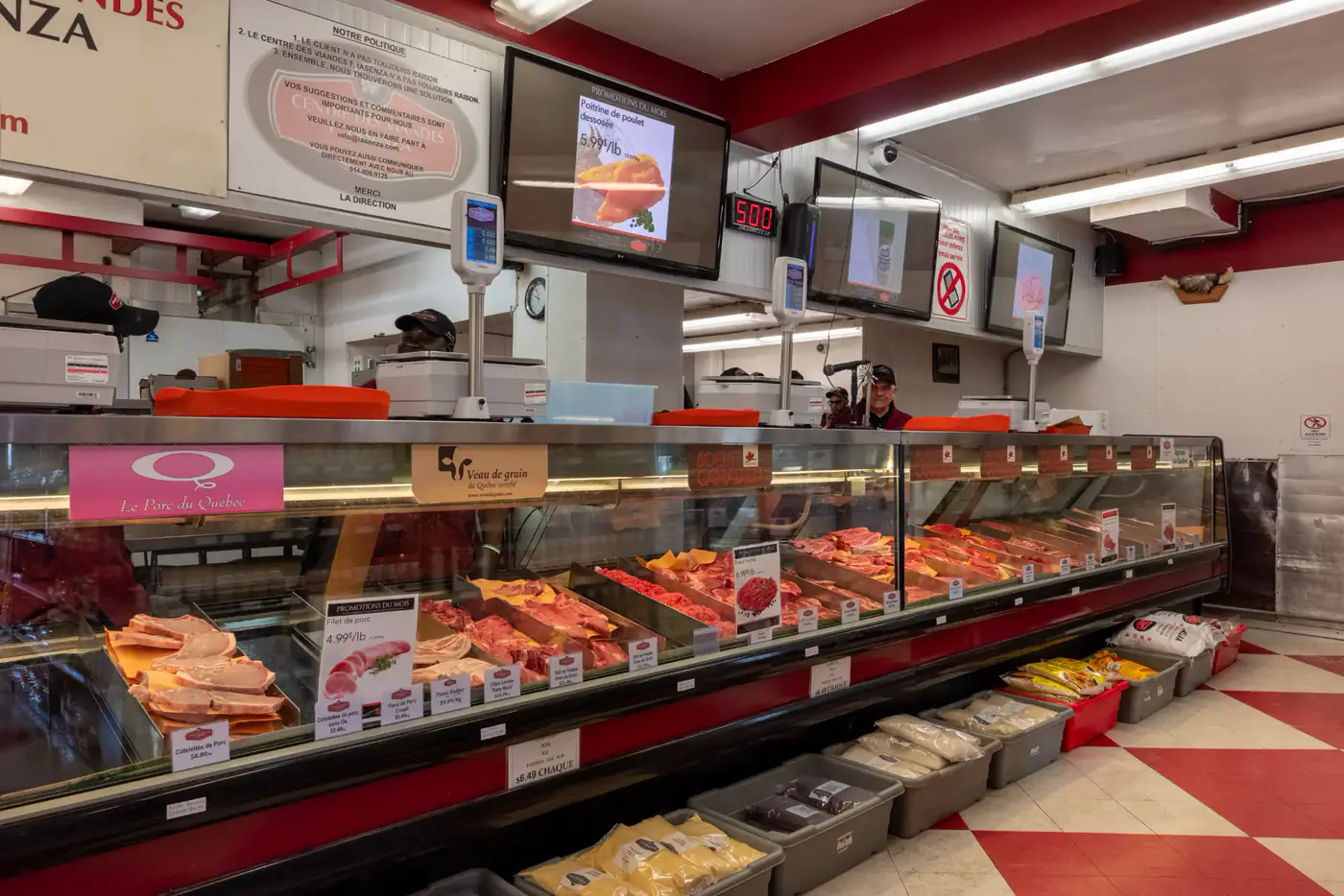 Refrigerated meat counter with screens above it at the Montréal-Nord store