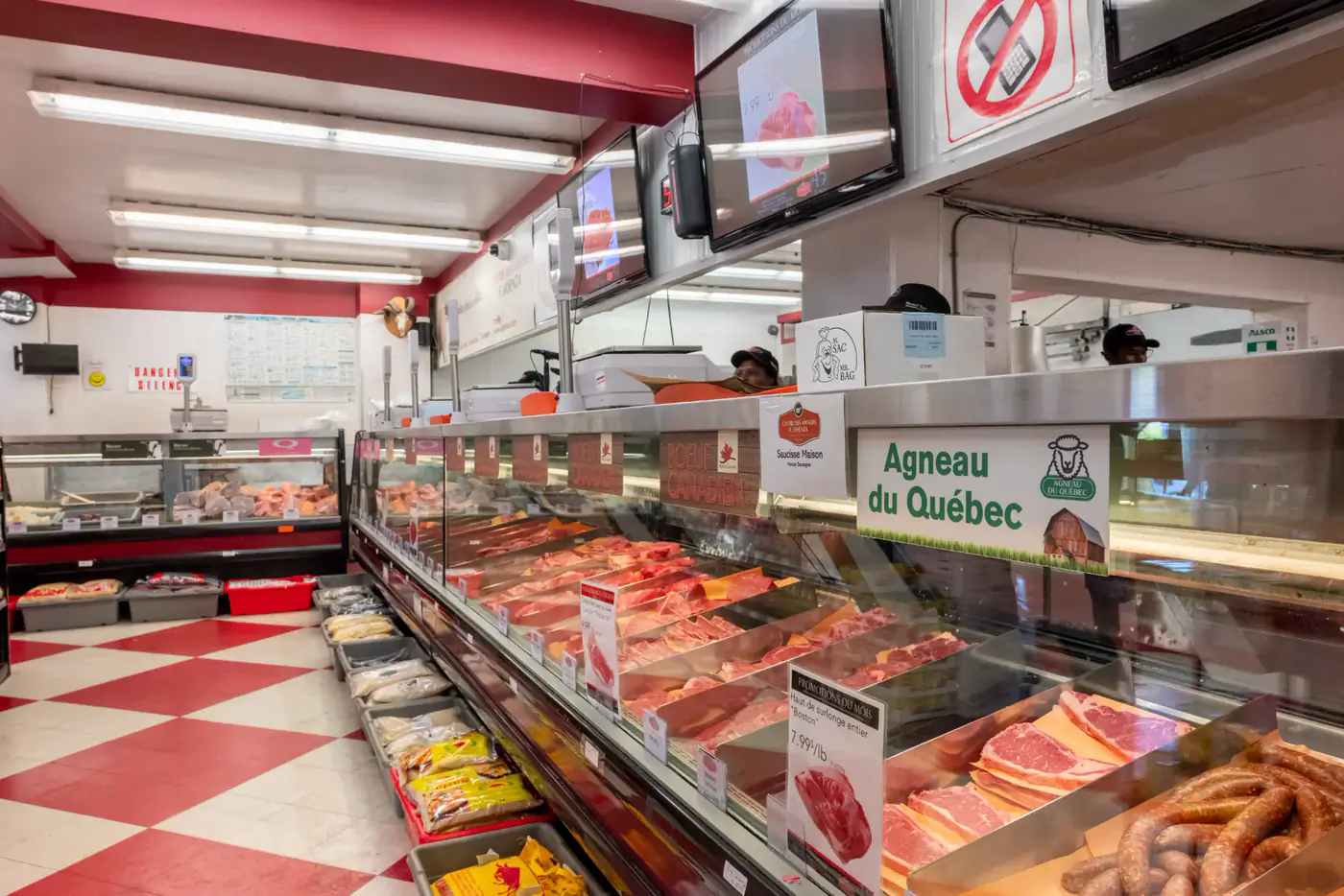 Aisle along the meat counter with a red and white checkered floor at the Montréal-Nord store