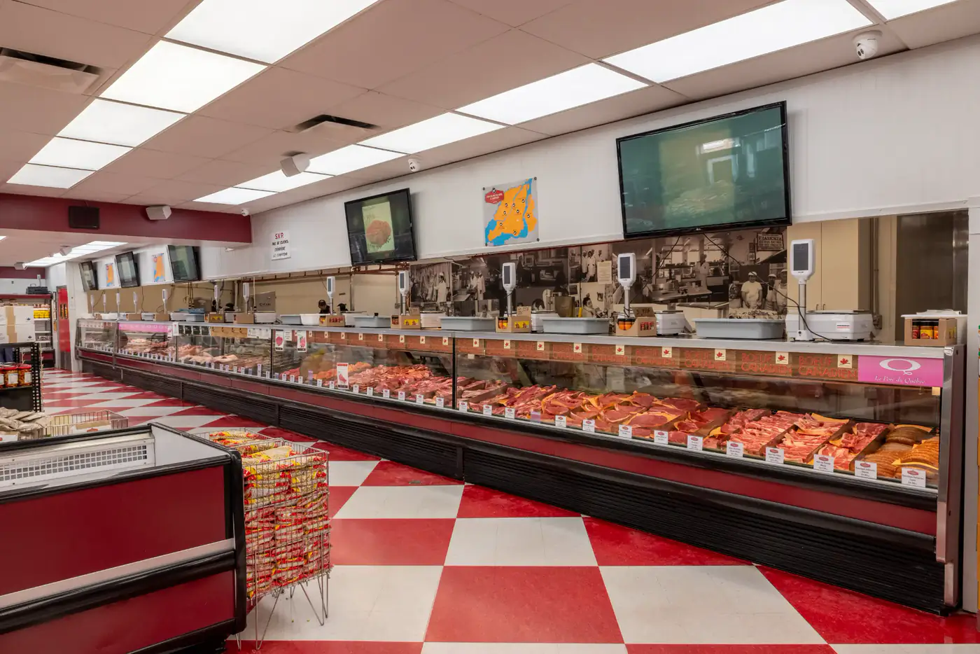 Long refrigerated meat counter at the St-Michel store, red and white checkered floor